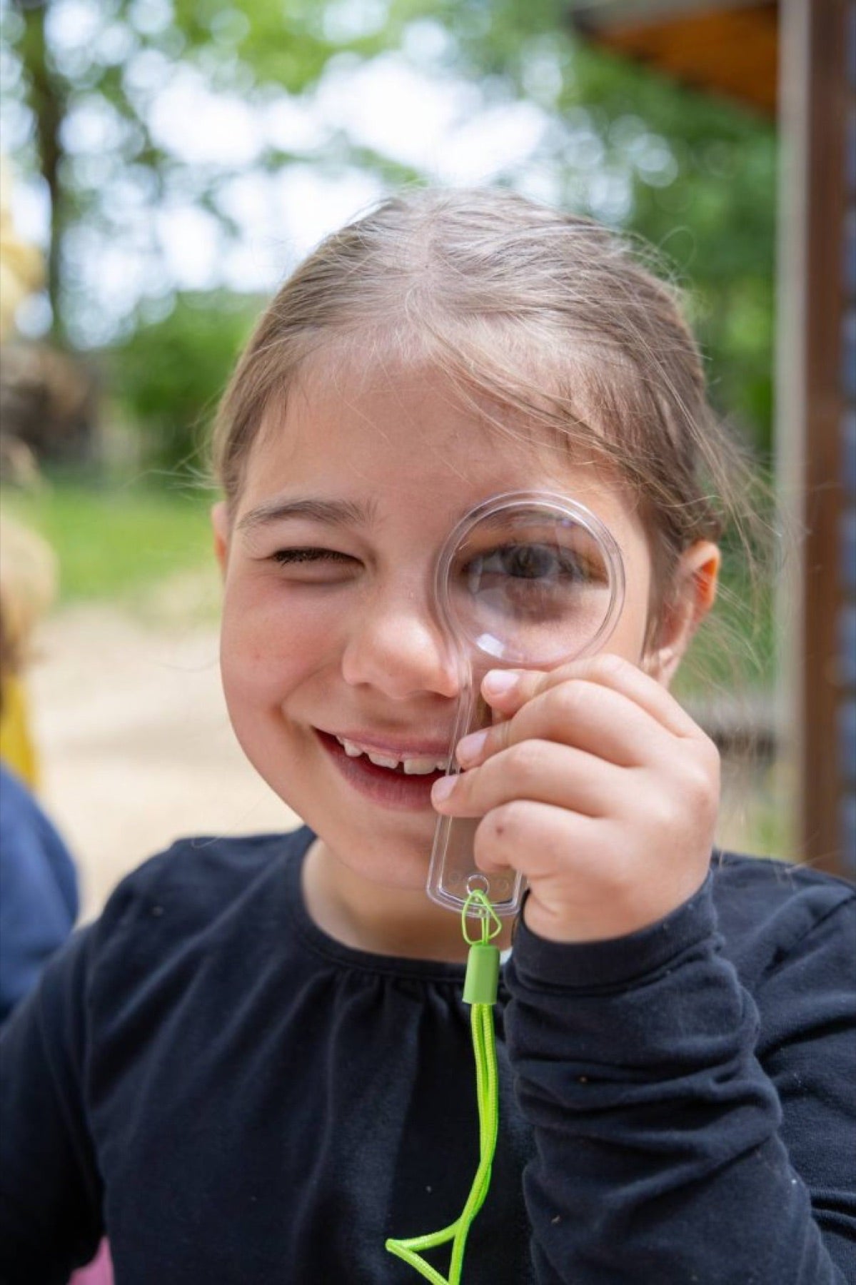 A child observing nature through a magnifying glass
